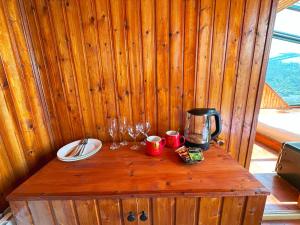 a wooden table with glasses and a coffee maker on it at Nika Hotel and Club 