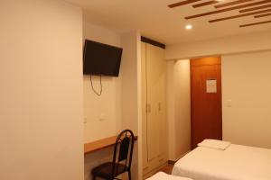 a bedroom with a bed and a tv on a wall at Hospedaje Arenas del Mar in Ilo