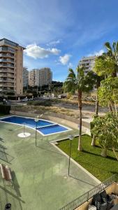 pusty basen z palmami i budynkami w obiekcie Buena vista, apartamento en la playa Finestrat w mieście Cala de Finestrat
