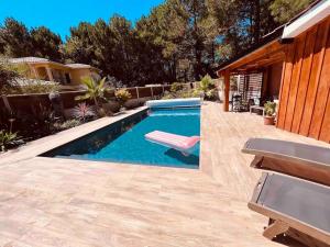 a swimming pool with a bench in a backyard at Le Doux Refuge in Gujan-Mestras