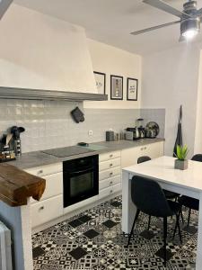 cocina con fogones y mesa con sillas en Charmant Appartement centre-ville, en Ajaccio