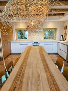 a large kitchen with a wooden table and chairs at Refuge Mil100 in Metzeral