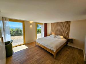 a bedroom with a bed and a large window at Refuge Mil100 in Metzeral
