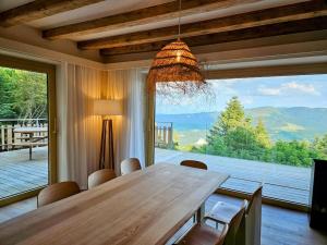a dining room table with chairs and a large window at Refuge Mil100 in Metzeral