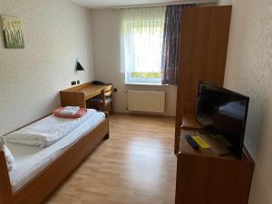 a small room with a bed and a television at Hotel am Stimbergpark in Oer-Erkenschwick