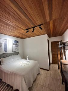 una camera con letto bianco e soffitto in legno di Apartamento Pituba Jardim a Itacaré