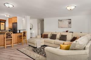 a living room with two couches and a kitchen at Island Club Luxury Apartments in Cape Town