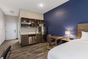Habitación de hotel con cama, cocina y escritorio en MainStay Suites Bourbonnais - Kankakee, en Bourbonnais