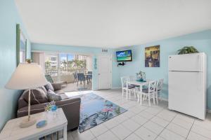 a living room with a couch and a refrigerator at Beach Club 403 in Marco Island