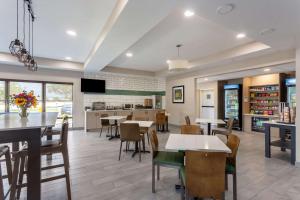 comedor y cocina con mesas y sillas en MainStay Suites Bourbonnais - Kankakee, en Bourbonnais