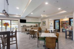 a dining room and kitchen with tables and chairs at MainStay Suites Bourbonnais - Kankakee in Bourbonnais