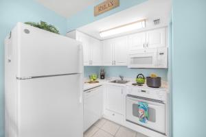 a kitchen with white appliances and a white refrigerator at Beach Club 403 in Marco Island
