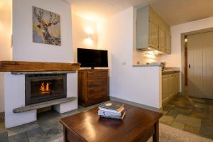 uma cozinha com uma sala de estar com lareira em Alpesmith - Bike & Ski apartments em Bardonecchia