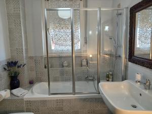 y baño con ducha, bañera y lavamanos. en Le Tre Civette en Sassari