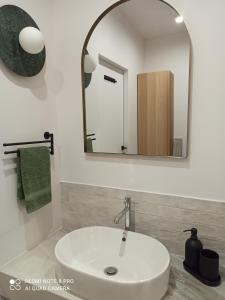 a bathroom with a white sink and a mirror at Apartament na Grochowej Centrum NOWOŚĆ in Białystok