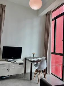 a living room with a television and a table with chairs at Studio Tower @ Empire Damansara in Petaling Jaya