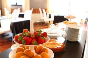 a plate of strawberries and oranges on a table at Hotel San Rocco in Muggia