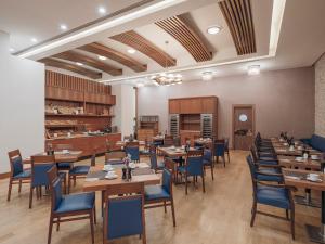 a restaurant with wooden tables and blue chairs at Selectum City Ataşehir in Istanbul