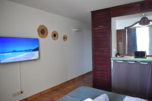 sala de estar con TV de pantalla plana en la pared en Ananas Premium, en La Trinité