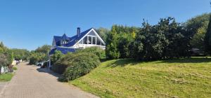 a blue and white house sitting on top of a hill at Am alten Deich in Sande