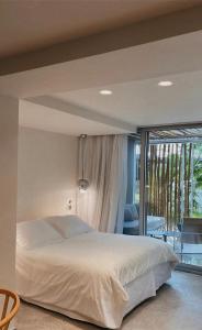 a bedroom with a large bed and a balcony at Ekies All Senses Resort, a Member of Design Hotels in Vourvourou