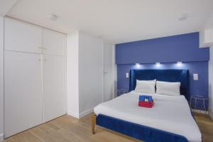 a bedroom with a white bed with a blue headboard at Rent a Room - 2P Passage du Caire in Paris