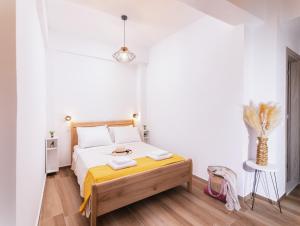 a white bedroom with a bed and a vase at Sifogiannis Rooms in Kamilari
