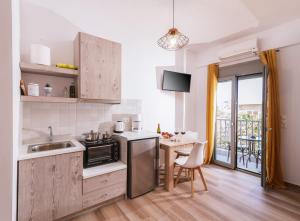 a kitchen with a sink and a table with a stove at Sifogiannis Rooms in Kamilari