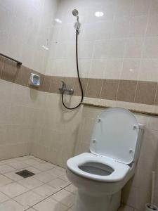 Santubong Suites Lower Level في كوتشينغ: حمام مع مرحاض ودش