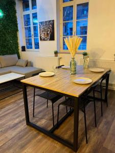 een houten tafel in een woonkamer met stoelen en een bank bij La palmeraie - duplex 4 pers in Condé-sur-lʼEscaut