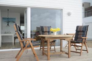 a dining room with a wooden table and chairs at Ferienwohnung OstseeBrise in Olpenitz