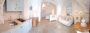Il dispose d'une cuisine et d'un salon avec un canapé et une table. dans l'établissement Trulli D'Angiò, à Alberobello