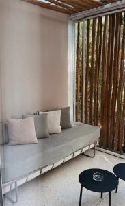 a couch sitting in a room with a window at Ekies All Senses Resort, a Member of Design Hotels in Vourvourou