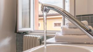 a bathroom sink with a faucet and a window at MonoliVi 35 - Affitti Brevi Italia in Modena