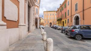 a city street with parked cars and buildings at MonoliVi 35 - Affitti Brevi Italia in Modena