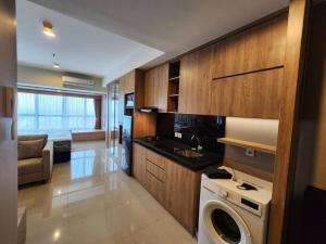 een keuken met een wasmachine in de kamer bij Irvine Suites Lantai 26-I2618 in Cikarang