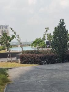 a street with trees and a body of water at Irvine Suites Lantai 26-I2618 in Cikarang