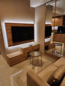 een woonkamer met een grote flatscreen-tv bij Irvine Suites Lantai 26-I2618 in Cikarang