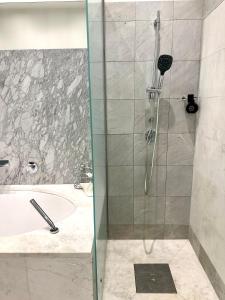 a shower with a glass door next to a tub at Sisi Apartment in Vienna