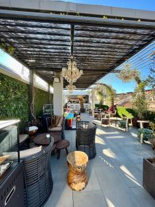 een patio met stoelen en tafels en een kroonluchter bij Mariposa Hotel Malaga in Málaga