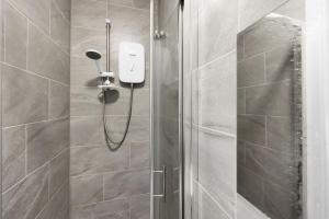 eine Dusche mit Duschkopf im Bad in der Unterkunft Luxury Hackney Suites in London