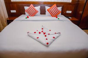 Una cama blanca con corazones rojos. en Hotel Yellow Pagoda Pokhara, en Pokhara