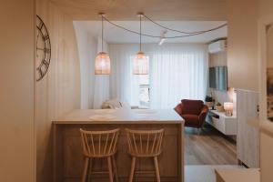 a kitchen with a kitchen island with two chairs at Apartament Nadmorski D39 Porto Łeba in Łeba