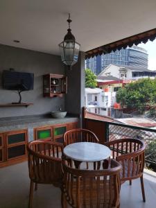 a table and chairs on a balcony with a view at Dalem Arum (for women only) in Bandung