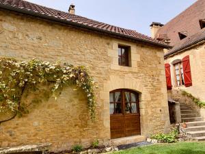 an old stone house with a wooden door and stairs at L'appartement du Pont de Cause in Saint-Cybranet