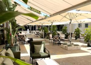 an outdoor patio with chairs and tables and umbrellas at Grande Real Villa Itália Hotel & Spa in Cascais