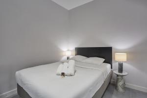 een slaapkamer met een wit bed en handdoeken bij Residense Montmartre by Studio prestige in Parijs