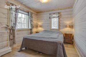 a bedroom with a bed in a wooden room at Hallahaukka in Ivalo