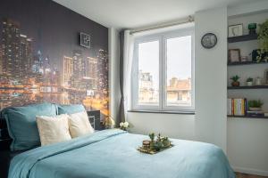 a bed in a bedroom with a view of a city at Captivating air-conditioned apartment by Paris in Le Kremlin-Bicêtre