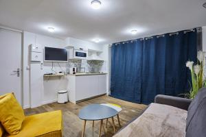 Una pequeña sala de estar con un sofá y una cocina. en Rent a Room - 2P Passage du Caire, en París